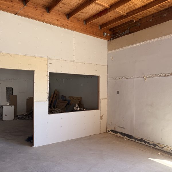 The new Drop Off room at Spinwave Laundry, framed and drywalled with a service pass-through window