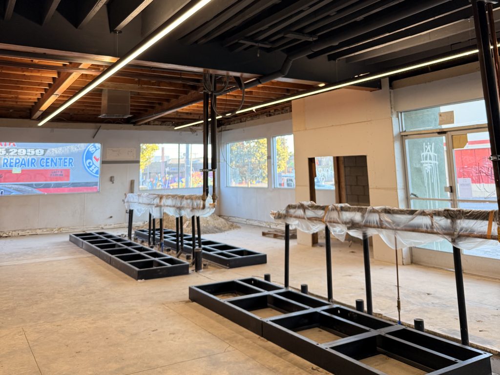 The new ceiling and LED lighting installed at Spinwave Laundry, with the machine bases already set on the floor